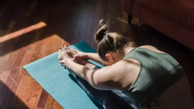 Frau dehnt sich auf Yogamatte